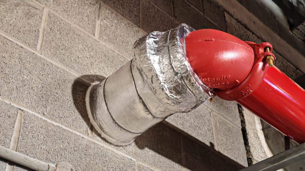 red pipe going into a wall